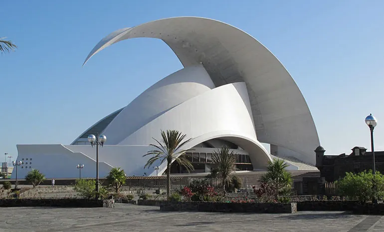The white, wave-shaped roof of the Auditorio de Tenerife in Santa Cruz, with palms and streetlights