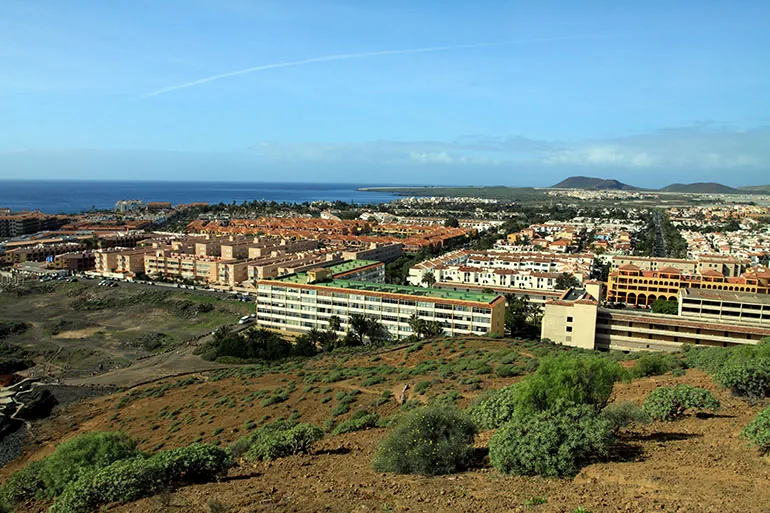 Residential complexes of Costa del Silencio from the hill, with the sea and volcanic cones beyond
