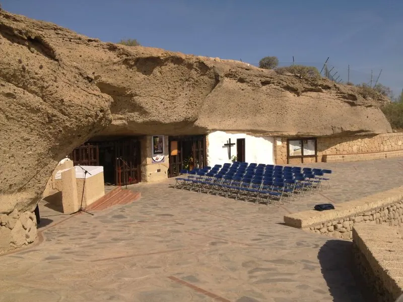 The Cueva del Hermano Pedro cave shrine, with an open-air altar and rows of blue chairs
