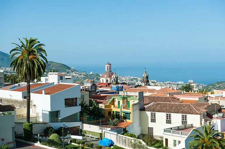 La Orotava’s rooftops with a church dome and bell towers, and the ocean on the horizon
