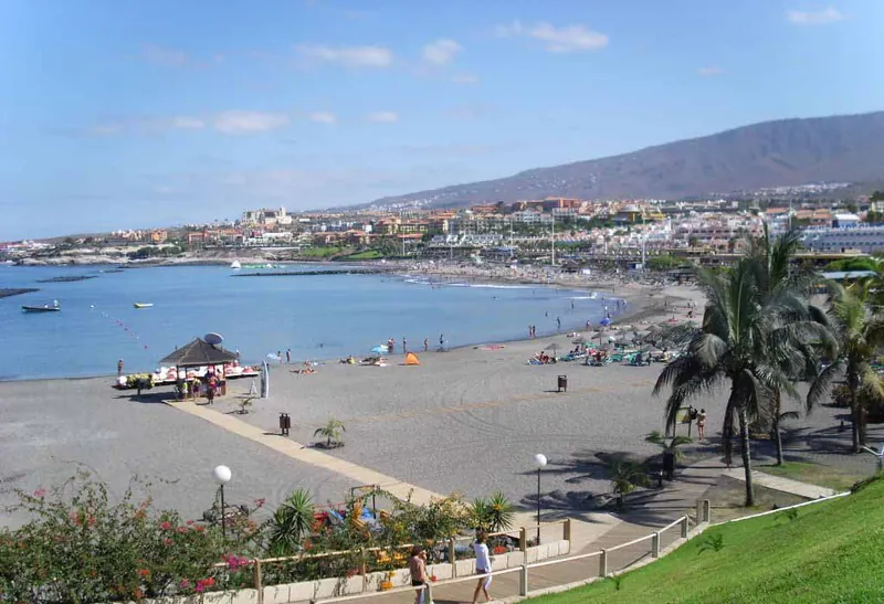 Playa de Fañabé from the promenade, with palm trees, bathers and Costa Adeje’s hotels