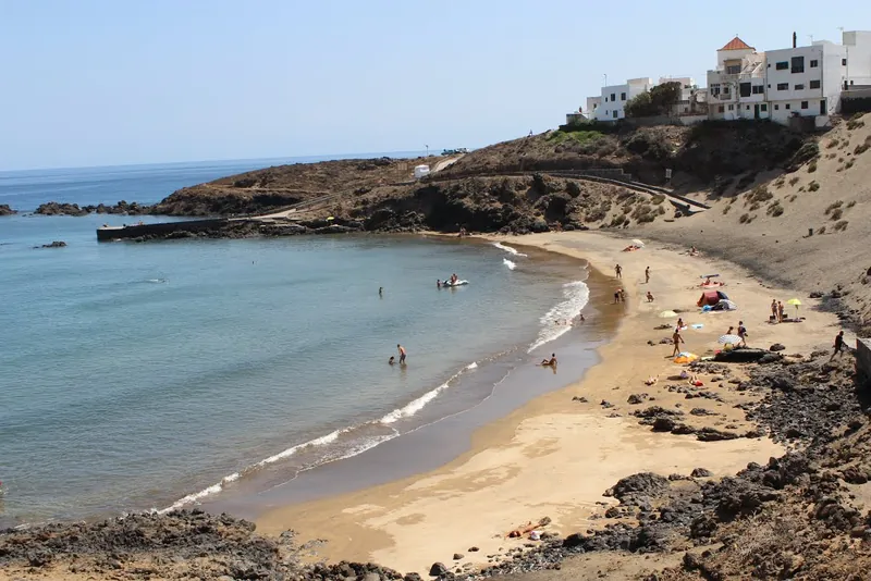 The golden-sand cove of Playa Grande in Porís de Abona, with white houses on the headland